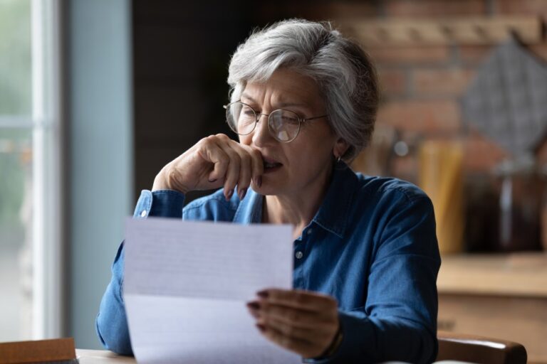 Senior woman reviewing a document to avoid tax scams targeting seniors