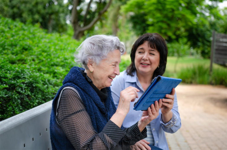 Elderly woman enjoying the company of a senior care specialist.