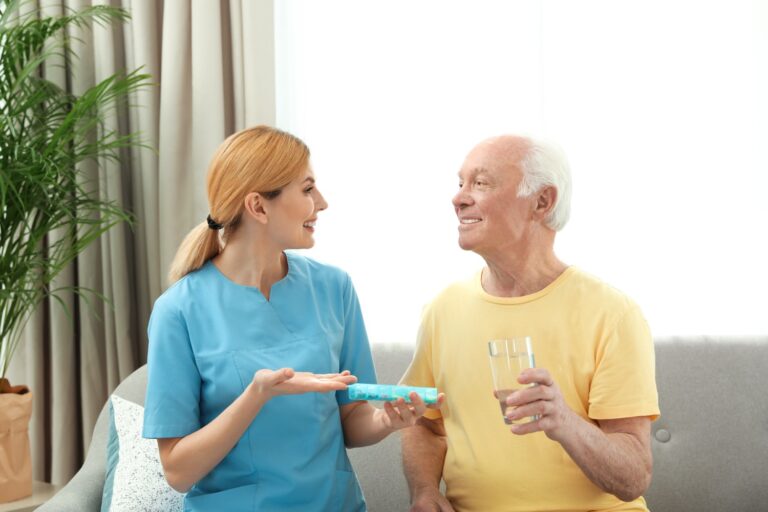 A live-in caregiver helps her client with medication.