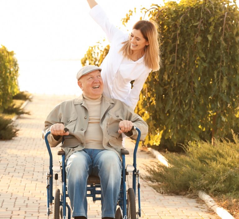 Senior and caregiver having fun outside.