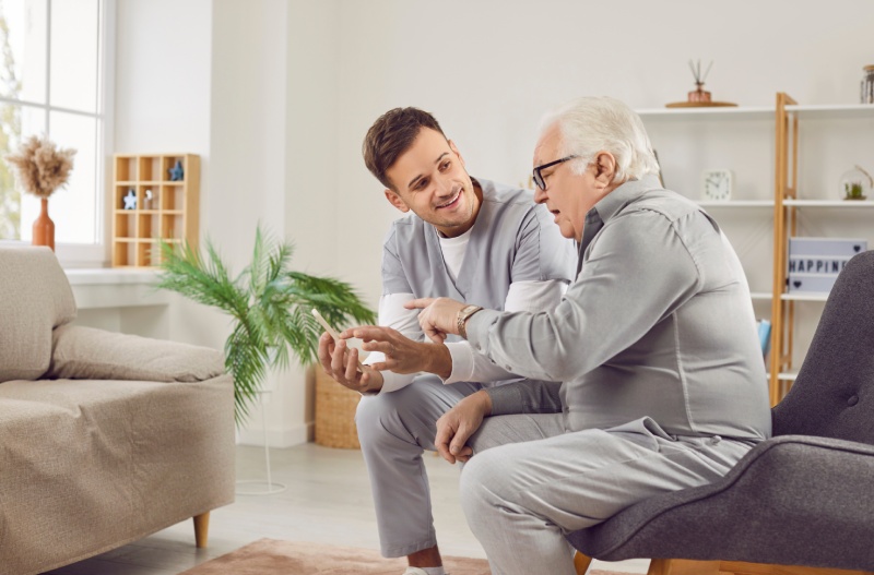 Caretaker and elderly man on chair.