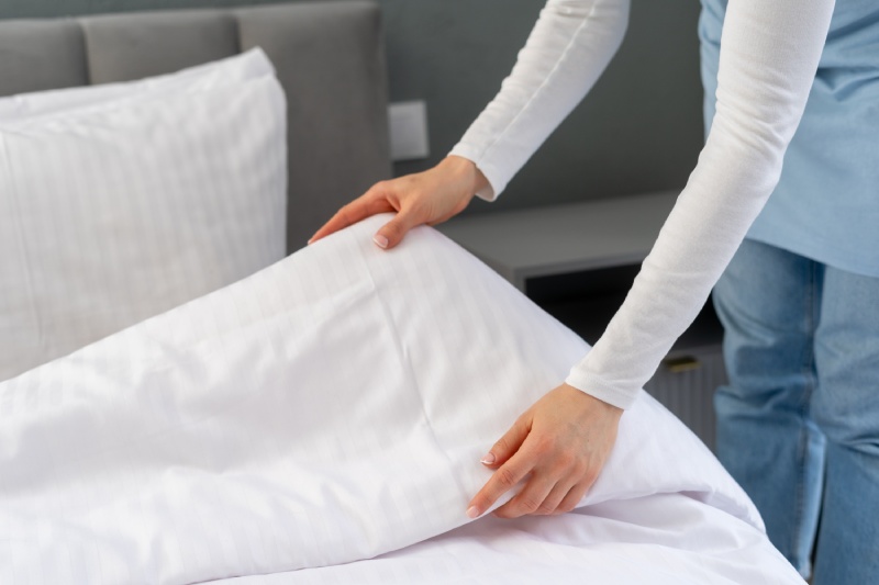 Caretaker changing sheets.