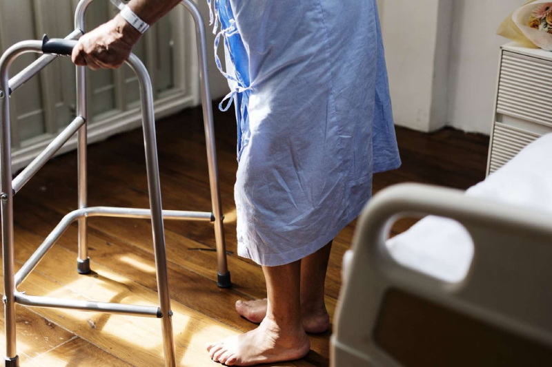 Senior in hospital walking with a walker